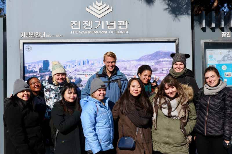 a male English teacher in Korea with his students